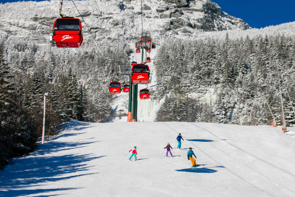 Red gondola going up a mountain on a winter day