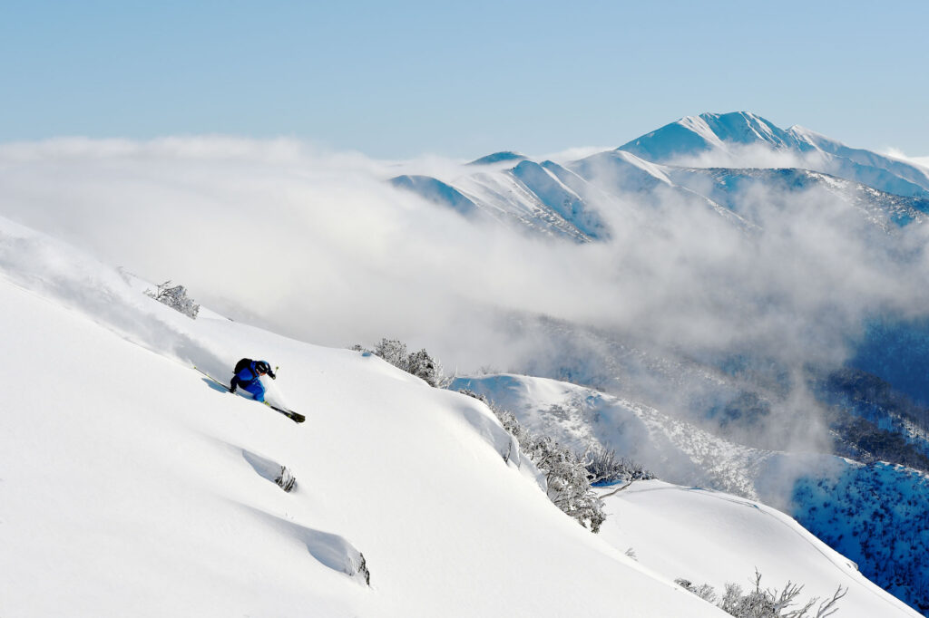 Skier going down a powder run in Australia on a sunny day