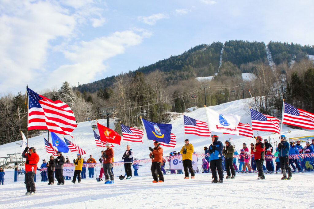 People holding American and military flags at ski resort