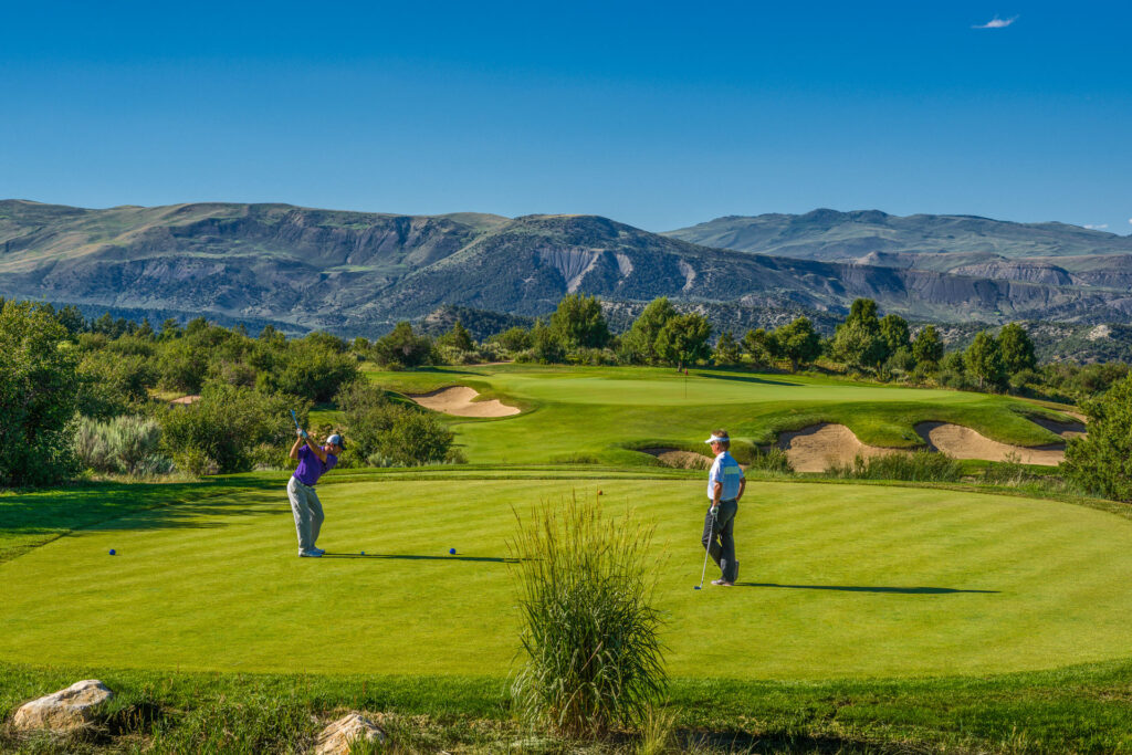 2 golfers on a golf coarse in the moutains