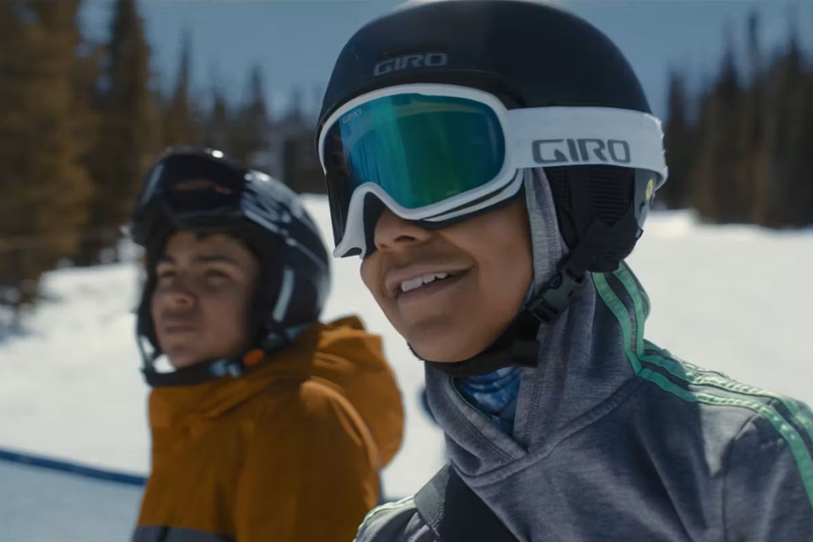 Close up image of 2 boys wearing ski goggles and helmets at ski resort