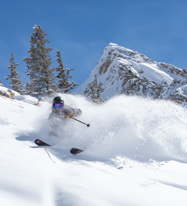Skier skiing in powder at Crested Butte on a sunny day