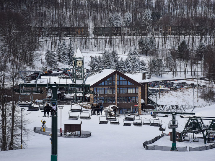 Image of a ski lift with a lodge in the background