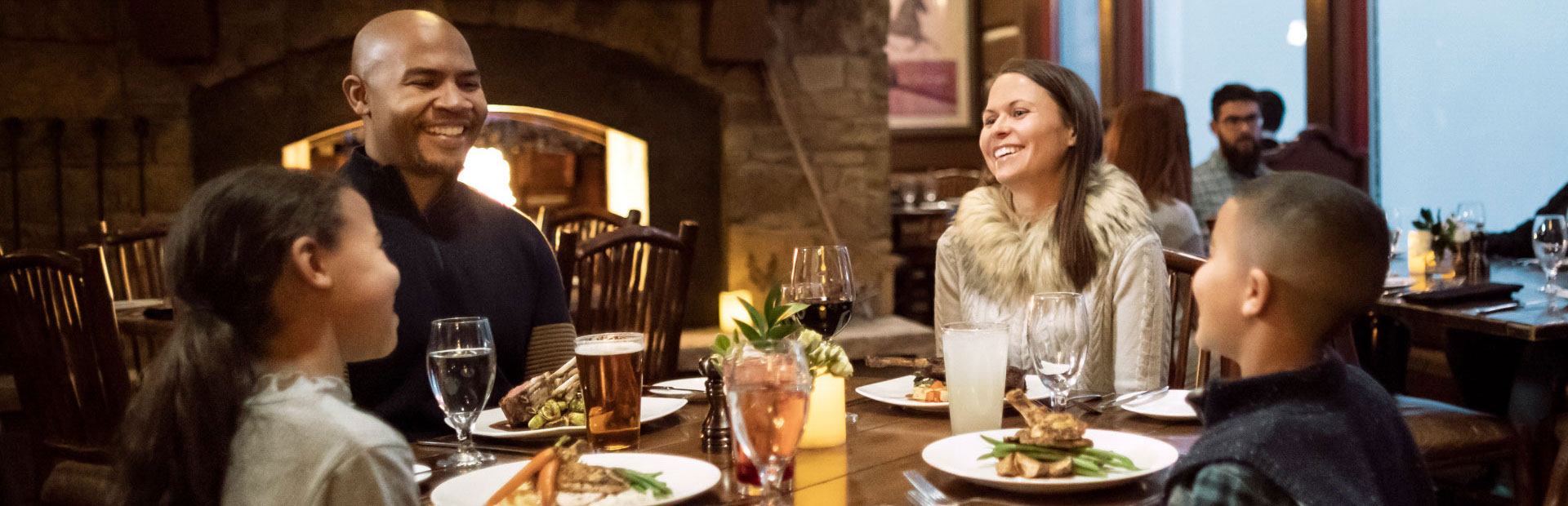 Family sitting at dinner table inside of a mountain resort