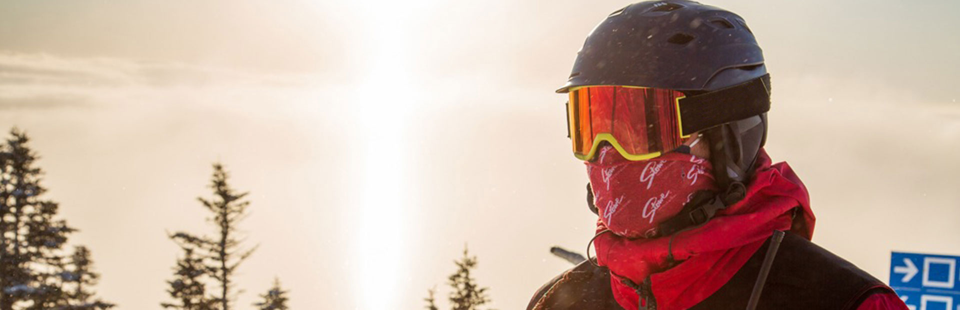 Person wearing ski helmet, goggles an and a red face covering